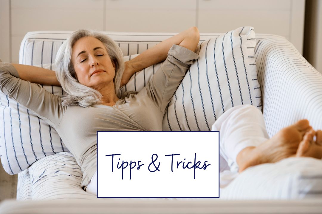 Entspannte Frau in den Wechseljahren liegt auf dem Sofa – Tipps für einen flachen Bauch und Wohlbefinden