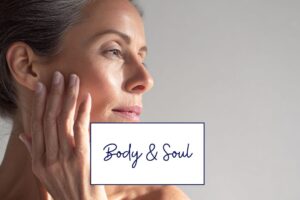 Frau in den Wechseljahren berührt sanft ihr Gesicht – Symbol für Haut, Zellalterung und ganzheitliche Balance.